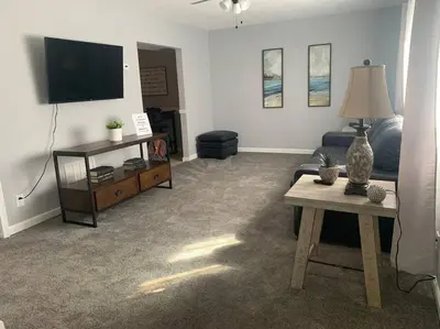 a living room with a couch and a table and a tv at Spacious Four Bedroom Attached Home in Springboro- Unit 1 in Springboro