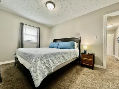 a bedroom with a bed with blue pillows and a table at A Great Place for Workers on Whitaker-Unit B in Hamilton