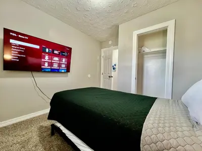 a bedroom with a bed and a tv on the wall at A Great Place for Workers on Whitaker-Unit B in Hamilton