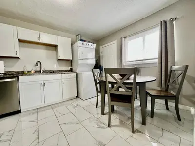 a kitchen with white cabinets and a table and chairs at A Great Place for Workers on Whitaker-Unit B in Hamilton