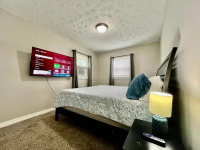 a bedroom with a bed and a tv on the wall at A Great Place for Workers on Whitaker-Unit B in Hamilton