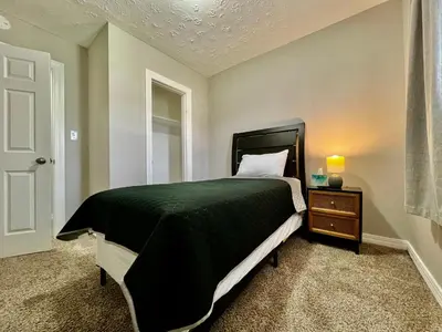 a bedroom with a bed with a black bedspread and a night stand at A Great Place for Workers on Whitaker-Unit B in Hamilton