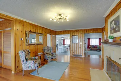 a living room with wooden walls and a fireplace at Spacious Lakefront House with Backyard Fire Pit in Monroe