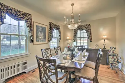a dining room with a table and chairs and windows at Half-Mi to Dawkins Rail Trail Family Home with Yard in Paintsville