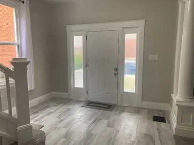 a hallway with a white door and wooden floors at 6 BR Home Just Minutes From Downtown Cincinnati in Cincinnati