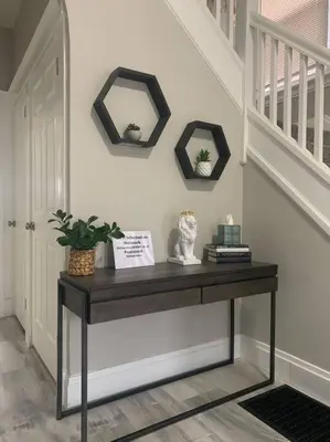 a console table in a hallway with two mirrors at 6 BR Home Just Minutes From Downtown Cincinnati in Cincinnati