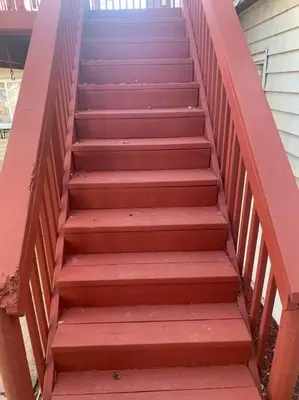 a set of stairs with a red railing at Comfortable Two Bedroom on Royal in Springboro in Springboro