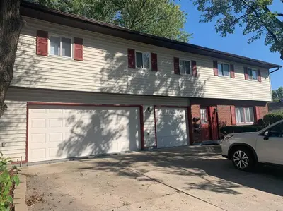 a car parked in front of a house with two garage doors at Comfortable Two Bedroom on Royal in Springboro in Springboro