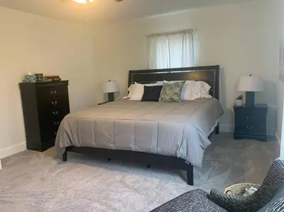 a bedroom with a bed with two night stands and two lamps at Remodeled Farm House with Plenty of Charm in Monroe