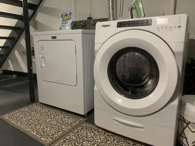 a white washing machine sitting next to a staircase at Remodeled Farm House with Plenty of Charm in Monroe