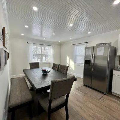 a kitchen with a table and a stainless steel refrigerator at Remodeled Farm House with Plenty of Charm in Monroe