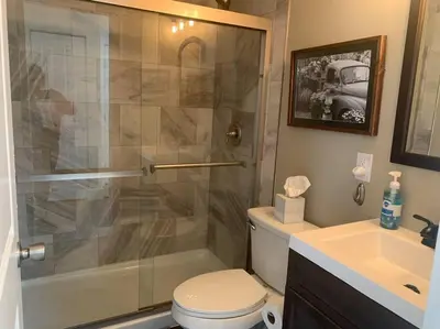 a bathroom with a shower and a toilet and a sink at Remodeled Farm House with Plenty of Charm in Monroe