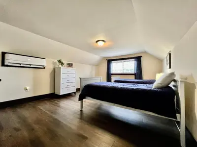 a bedroom with a bed and a dresser and a tv at Newly Renovated Historic mansion ☆ 8 Bedrooms in Hamilton