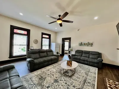 a living room with couches and a ceiling fan at Newly Renovated Historic mansion ☆ 8 Bedrooms in Hamilton