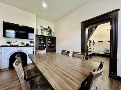 a dining room with a wooden table and a fireplace at Newly Renovated Historic mansion ☆ 8 Bedrooms in Hamilton