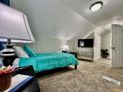 a bedroom with a green bed and a flat screen tv at Charming 4BR Home in Liberty Township w Large Deck in Maustown