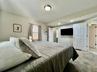 a bedroom with a large bed and a flat screen tv at Charming 4BR Home in Liberty Township w Large Deck in Maustown