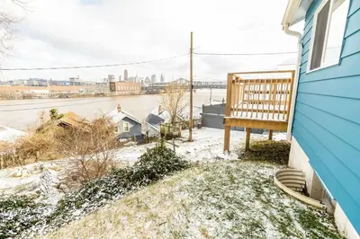 a bench sitting on the side of a blue house at Cozy Riverfront Bungalow with Stunning Views in Covington