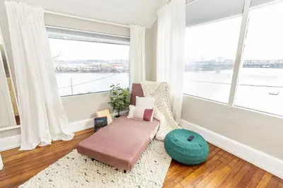 a living room with a couch and a large window at Cozy Riverfront Bungalow with Stunning Views in Covington