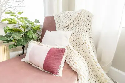 a pillow sitting on a chair with a blanket at Cozy Riverfront Bungalow with Stunning Views in Covington
