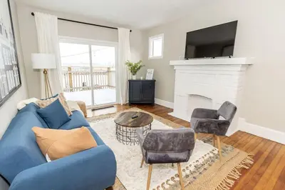a living room with a blue couch and a fireplace at Cozy Riverfront Bungalow with Stunning Views in Covington