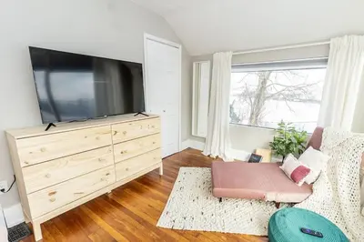a living room with a large flat screen tv at Cozy Riverfront Bungalow with Stunning Views in Covington
