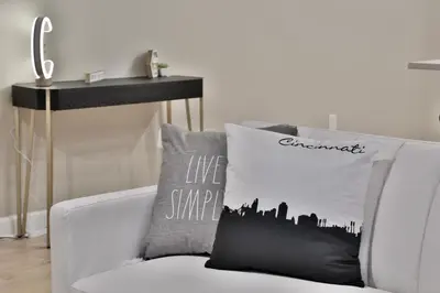 a living room with a white couch with a city pillow at *New* XquisiteMidCenturyM0d~ Condo *OTR* w/Parking in Cincinnati