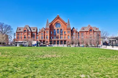 a large brick building with a grass field in front of it at *New* XquisiteMidCenturyM0d~ Condo *OTR* w/Parking in Cincinnati