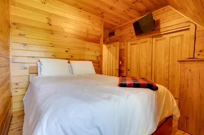 a bedroom with a bed in a wooden cabin at Walhonding Woods Secluded Farmland Retreat! in Walhonding