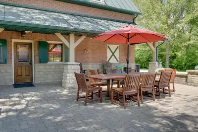 a wooden table and chairs with a red umbrella at Walhonding Woods Secluded Farmland Retreat! in Walhonding