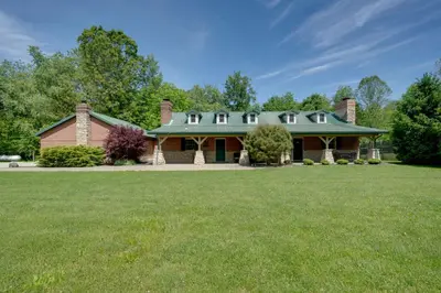 a large brick house with a green roof at Walhonding Woods Secluded Farmland Retreat! in Walhonding