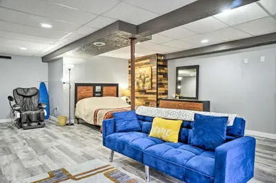 a living room with a blue couch and a bed at Zen Studio about 20 Min to Downtown Columbus! in Blacklick