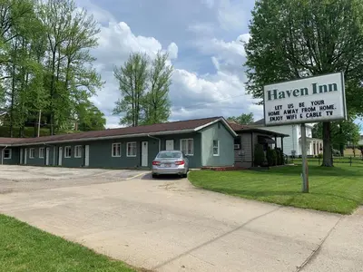a car parked in front of a house with a sign at HAVEN INN in Glendale
