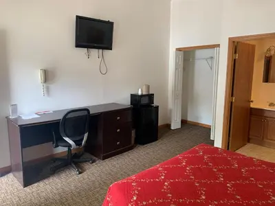 a bedroom with a desk and a bed and a television at HAVEN INN in Glendale