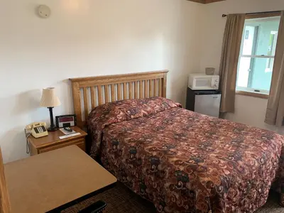 a hotel room with a bed and a microwave at HAVEN INN in Glendale