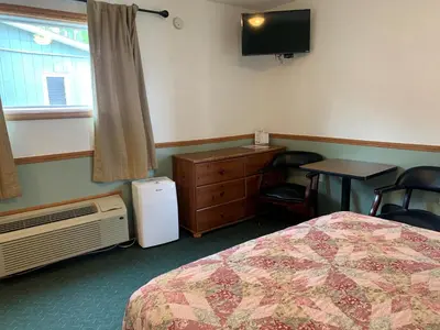 a hotel room with a bed and a table and a tv at HAVEN INN in Glendale