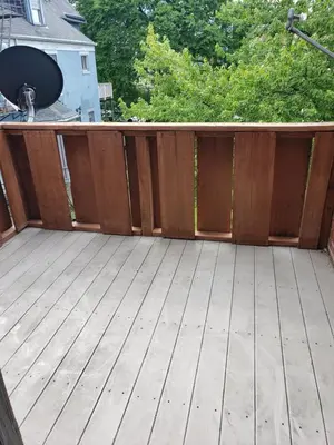 a wooden deck with a fence on a house at Spacious Industrial split level with a Balcony in Cincinnati