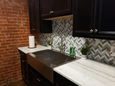 a kitchen with a sink and a brick wall at Fresh Modern Industrial split level in Cincinnati