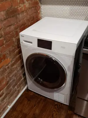 a washing machine sitting next to a brick wall at Modern style and comfort near UC in Cincinnati