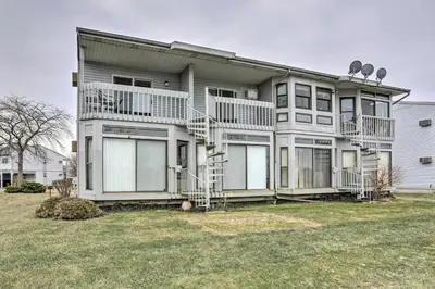 a large house with balconies and a yard at Condo with Balcony, Dock and Access to Lake Erie in Sand Beach