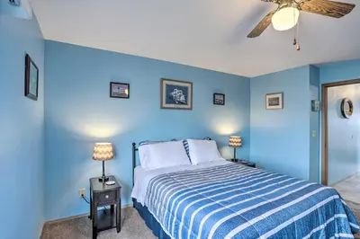 a blue bedroom with a bed and a ceiling fan at Condo with Balcony, Dock and Access to Lake Erie in Sand Beach
