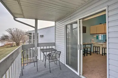 a patio with chairs and a table on a balcony at Condo with Balcony, Dock and Access to Lake Erie in Sand Beach