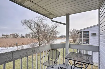 a patio with a table and chairs on a porch at Condo with Balcony, Dock and Access to Lake Erie in Sand Beach