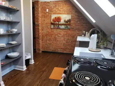 a kitchen with a stove and a brick wall at Modern Rustic split level with balcony in Cincinnati
