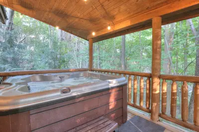 a jacuzzi tub on a screened in porch at Apple Blossom Cabin by Amish Country Lodging in Millersburg