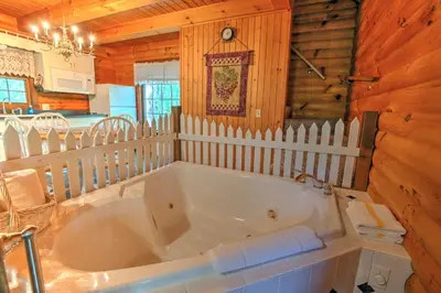 a large white tub in a room with a white fence at Apple Blossom Cabin by Amish Country Lodging in Millersburg