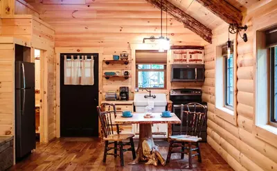 a kitchen with a table and chairs in a cabin at Cricket Hill Treehouse D by Amish Country Lodging in Millersburg