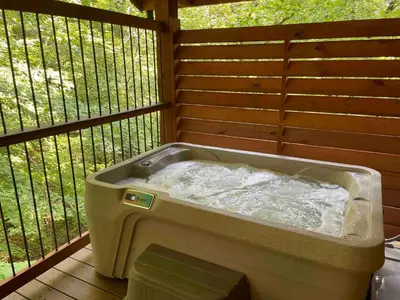 a bath tub sitting on top of a deck at Cricket Hill Treehouse D by Amish Country Lodging in Millersburg