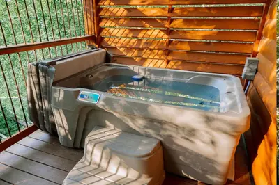 a large bath tub sitting next to a fence at Cricket Hill Treehouse C by Amish Country Lodging in Millersburg