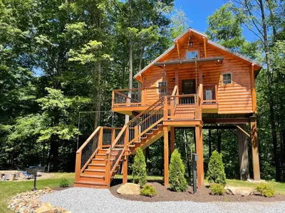 a tree house with a staircase leading up to it at Cricket Hill Treehouse B by Amish Country Lodging in Millersburg